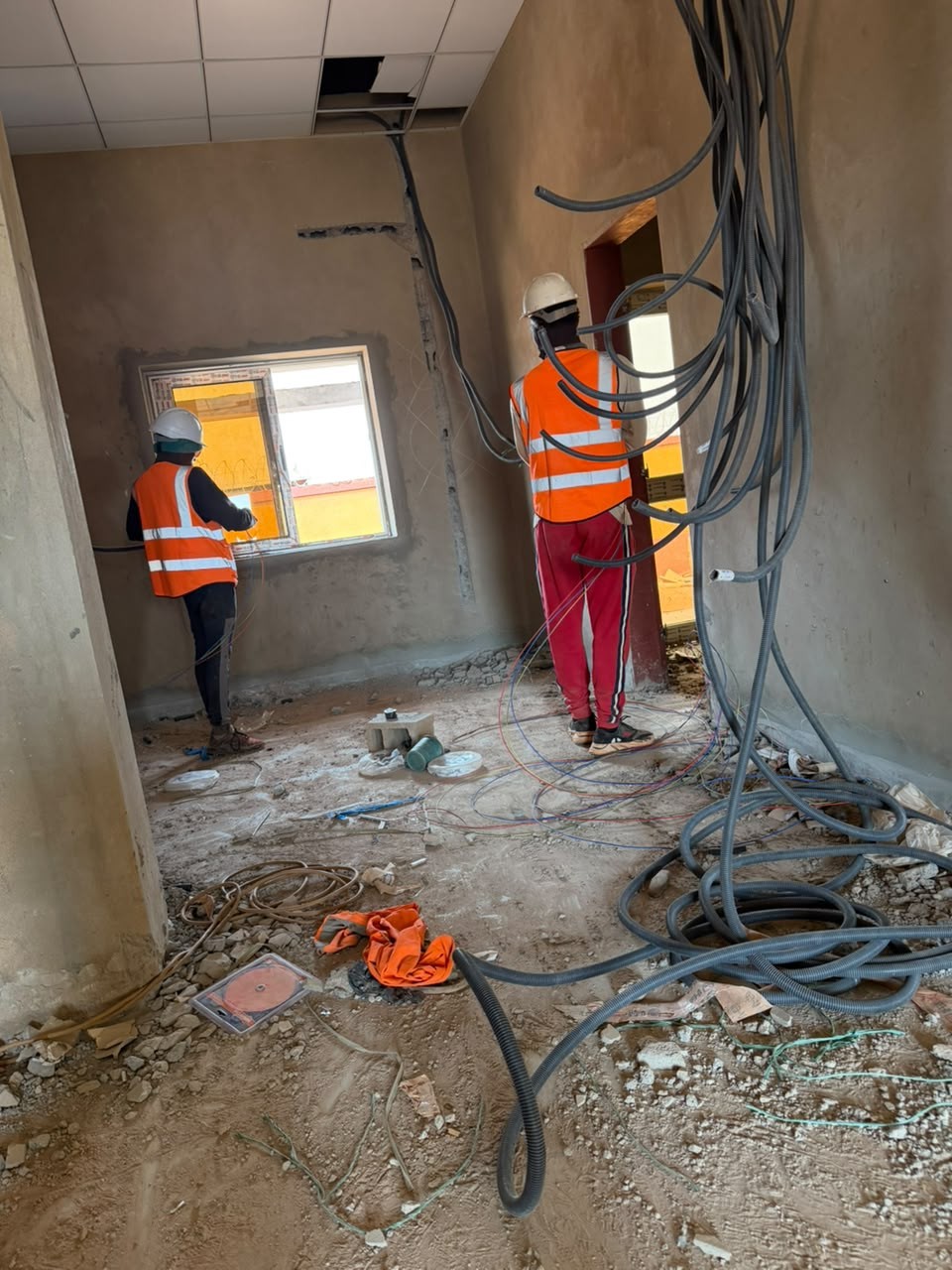 Techniciens et câblage dans un bâtiment en construction